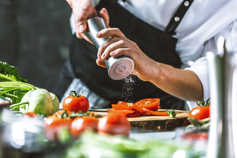 Cuisinier en train de saler un plat